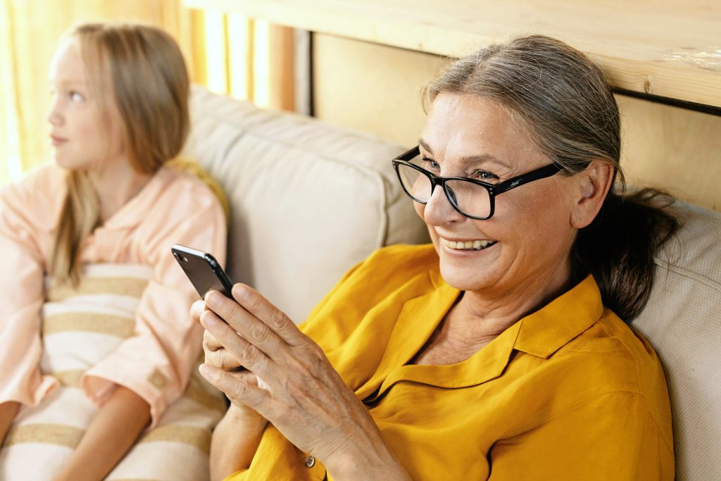 Zwei Frauen sitzen gemeinsam und schauen auf ein Smartphone